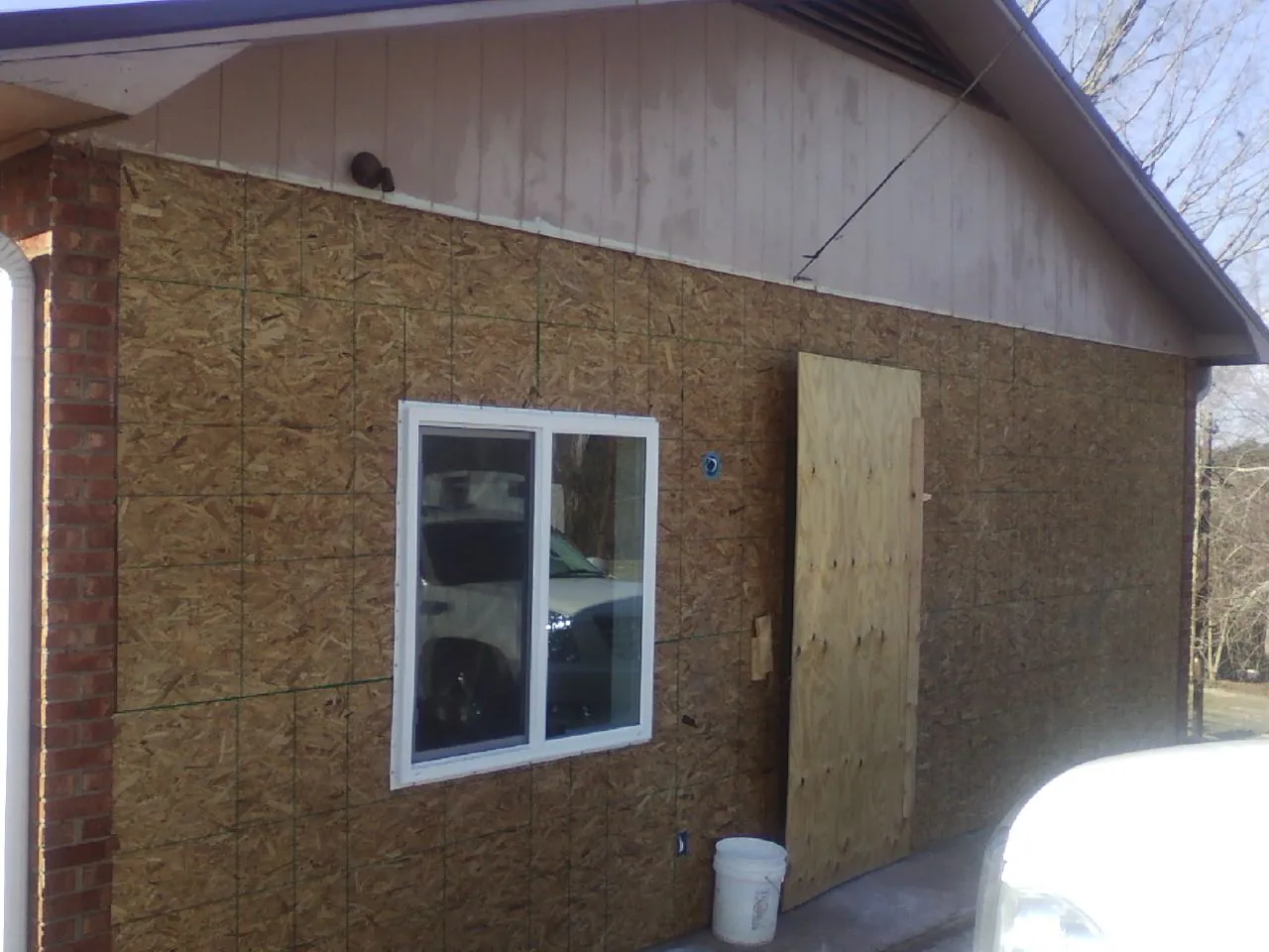 OSB sheathing on a garage addition wall before siding in Florissant
