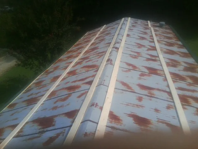 Rusted metal roof panels with new wood purlins before replacement — Storm Damage Roof Repair in Florissant by Roofing Brothers